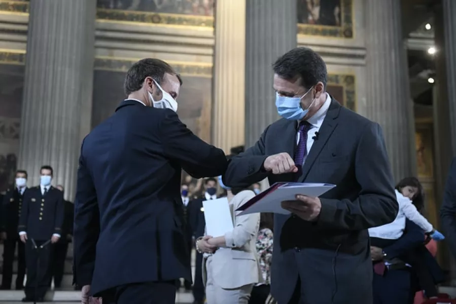 French President Emmanuel Macron, left, congratulates an unidentified new French citizen after he was granted citizenship (Julien de Rosa/AP)