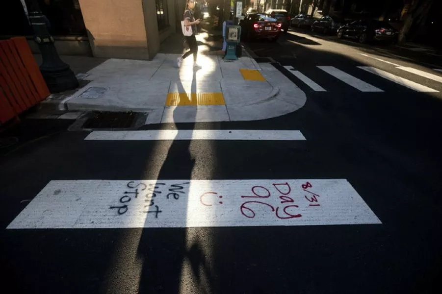 Graffiti drawn by protesters lines a crossing in Portland (Noah Berger/AP)