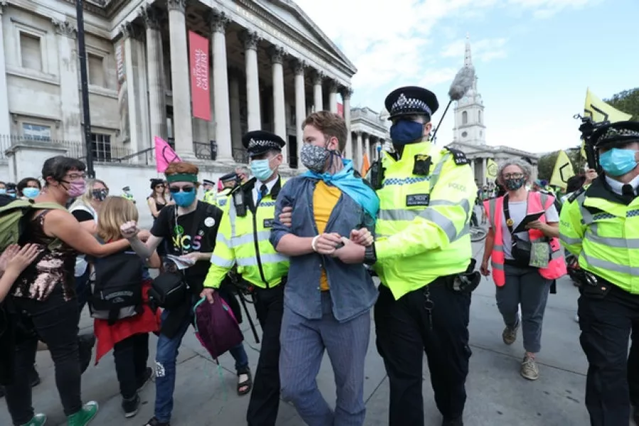 Protesters are removed by police officers during an Extinction Rebellion protest in Trafalgar Square (Yui Mok/PA)