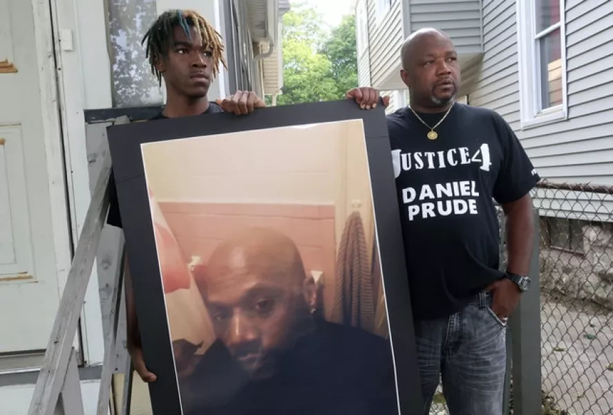 Daniel Prude’s brother Joe Prude (right) and Daniel’s nephew Armin, stand with a picture of Daniel Prude (Ted Shaffrey/AP)