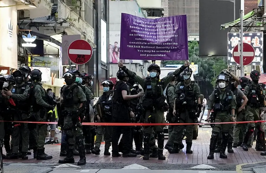 Hong Kong police officers raise a warning banner (Vincent Yu/AP)