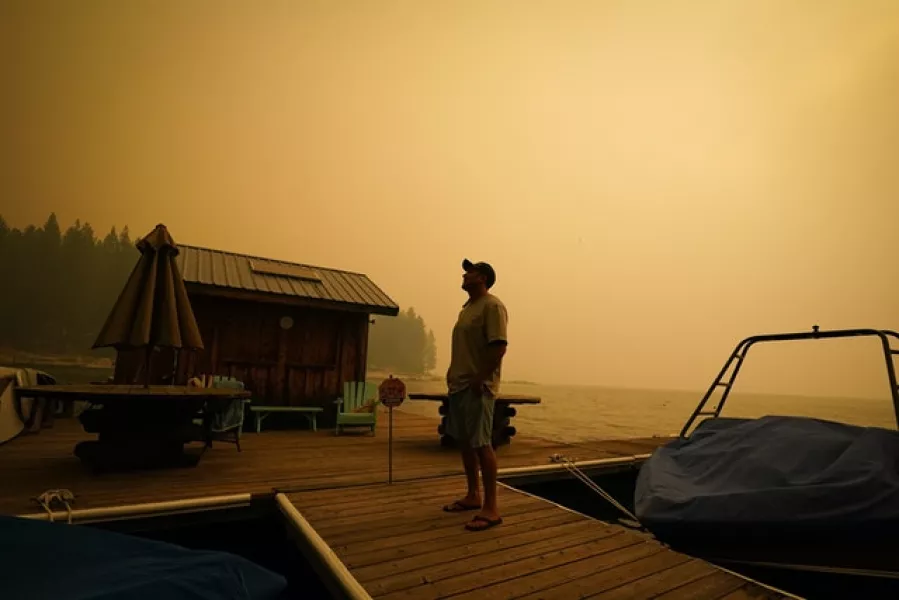 A business owner, who declined to give his name, looks up at the smoke-covered sky from the Creek Fire in Shaver Lake, California (Marcio Jose Sanchez/AP)