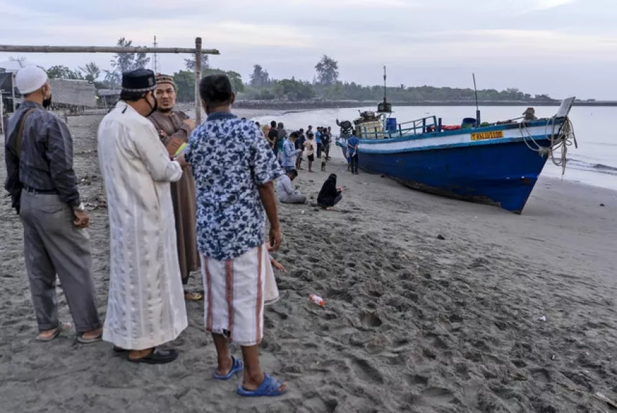 Local residents inspect the boat that carried hundreds of ethnic Rohingya people (Zik Maulana/AP)