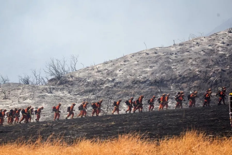 Members of a hand crew work on the fire line in Yucaipa, California (Ringo HW Chiu/AP)
