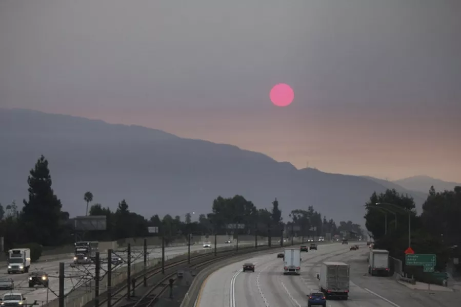 Smoke from wildfires burning east of Los Angeles dims the sunrise (John Antczak/AP)