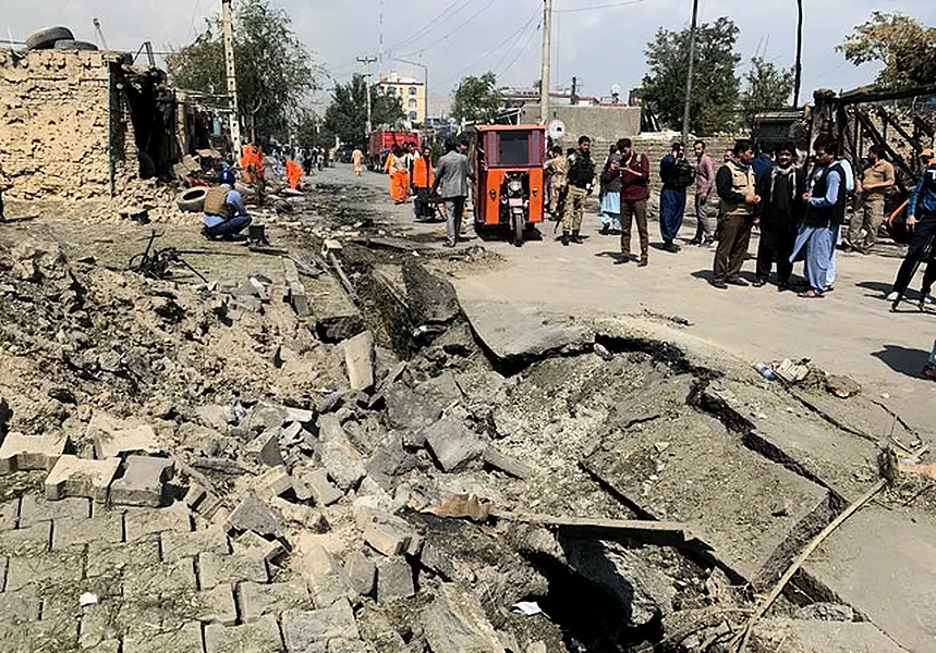 Afghan security personnel and municipality workers at the site of the explosion (Rahmat Gul/AP)