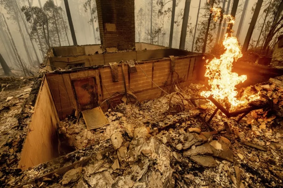 Flames burn at a home levelled by the Creek Fire along Highway 168 in Fresno County, California (Noah Berger/AP)