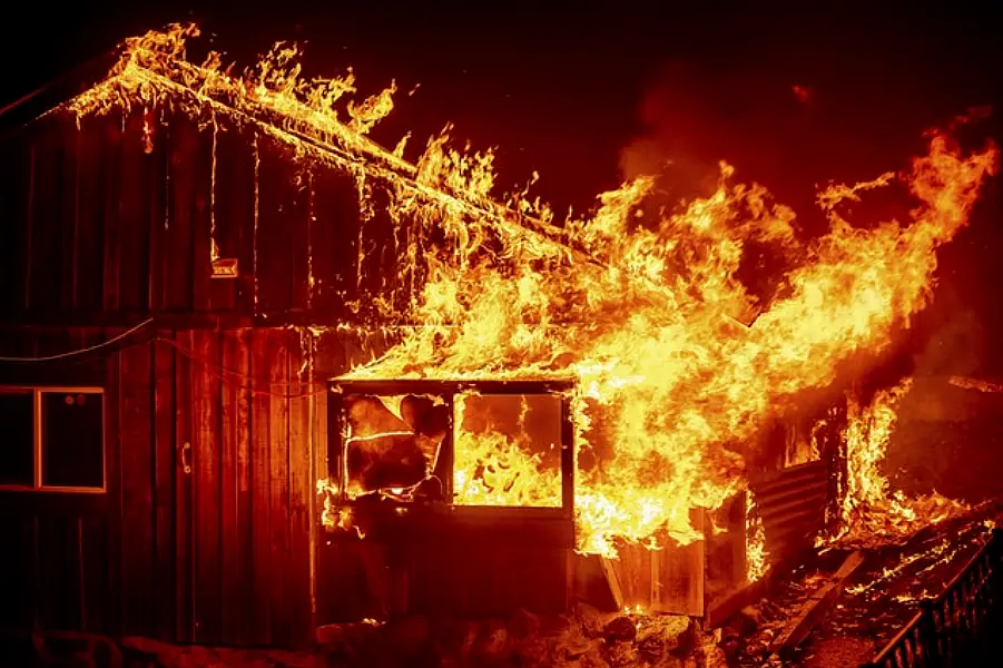 Flames shoot from a home in Butte County, California (Noah Berger/AP)