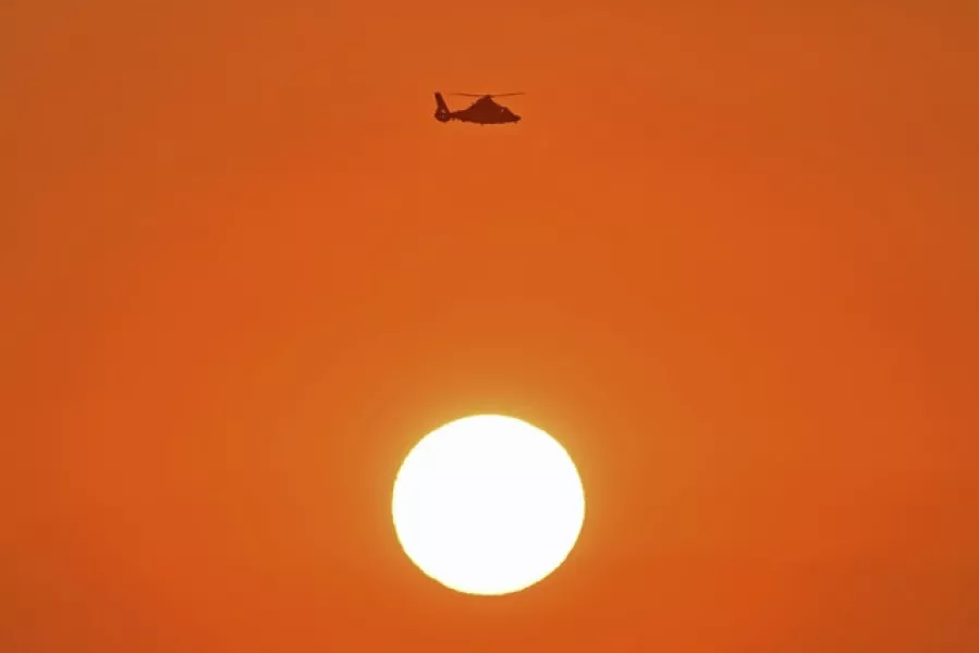 A Coast Guard helicopter flies above the setting sun while patrolling the waters near the Golden Gate Bridge (Jose Carlos Fajardo/Bay Area News Group/AP)