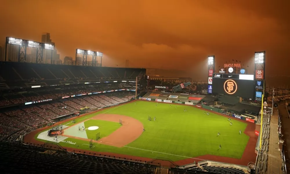 Smoke from California wildfires obscures the sky over Oracle Park as the Seattle Mariners take batting practice before their baseball game against the San Francisco Giants (Tony Avelar/AP)