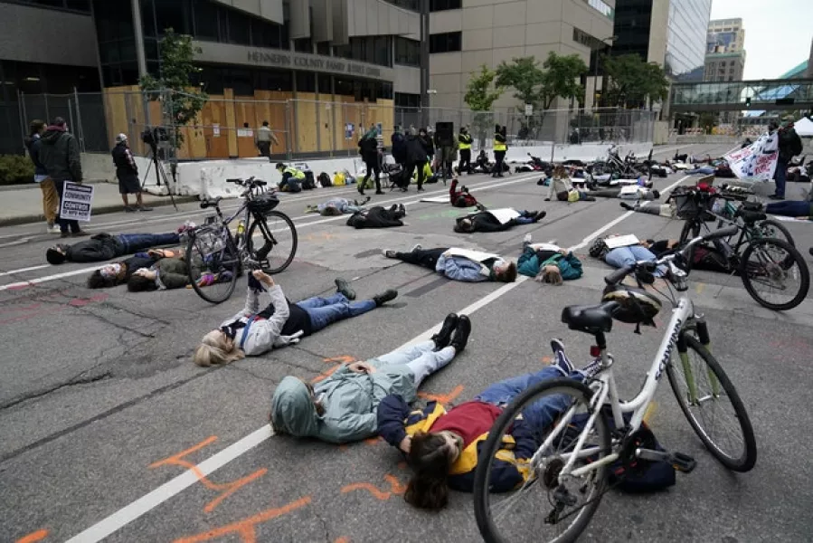 Protesters hold a die-in outside the Hennepin County Family Justice Centre where four former Minneapolis police officers appeared at a hearing (Jim Mone/AP)