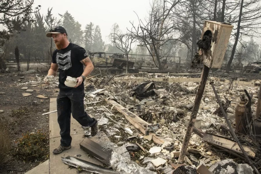 Derek Trenton from Talent, Oregon salvages some items at his parents’ home (Paula Bronstein/AP)