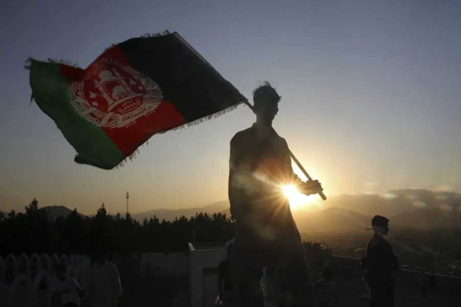 A man waves an Afghan flag during Independence Day celebrations in Kabul (AP)