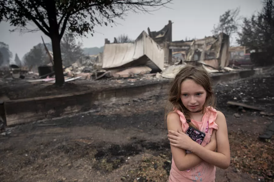 Ellie Owens, eight, from Grants Pass, surveys fire damage in Oregon (AP)
