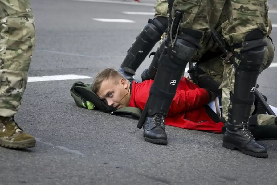 Riot police officers detain a protester (AP)