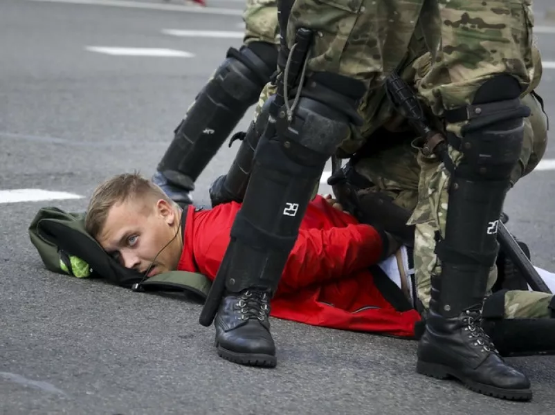 Riot police officers detain a protester in  Minsk on Sunday (AP)