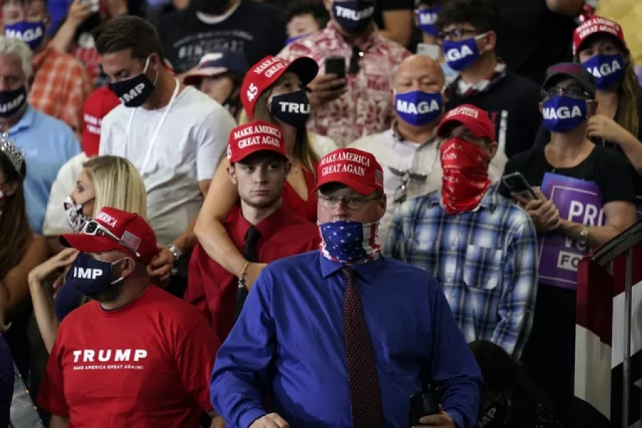 Part of the crowd gathered behind the president, who were told to wear face masks (Andrew Harnik/AP)