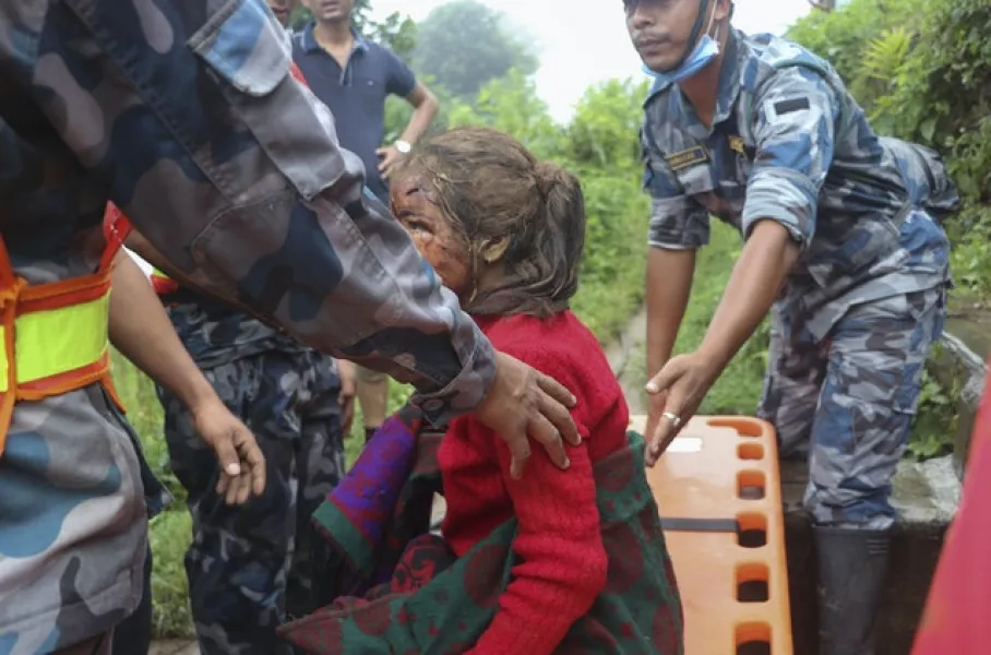 An injured girl is rescued after a landslide (AP)