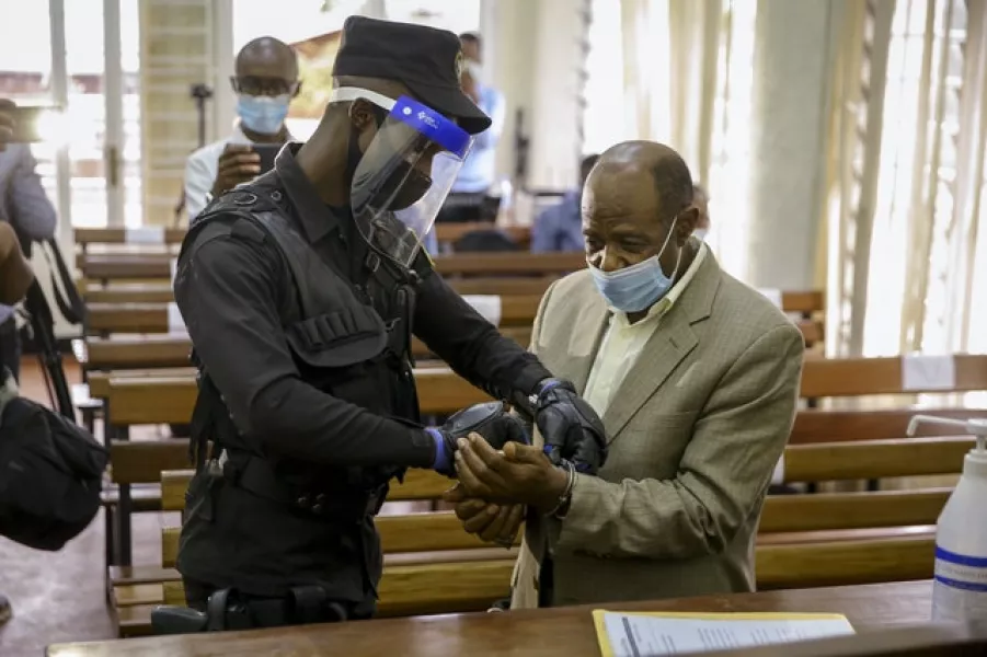 A policeman handcuffs Paul Rusesabagina (Muhizi Olivier/AP)