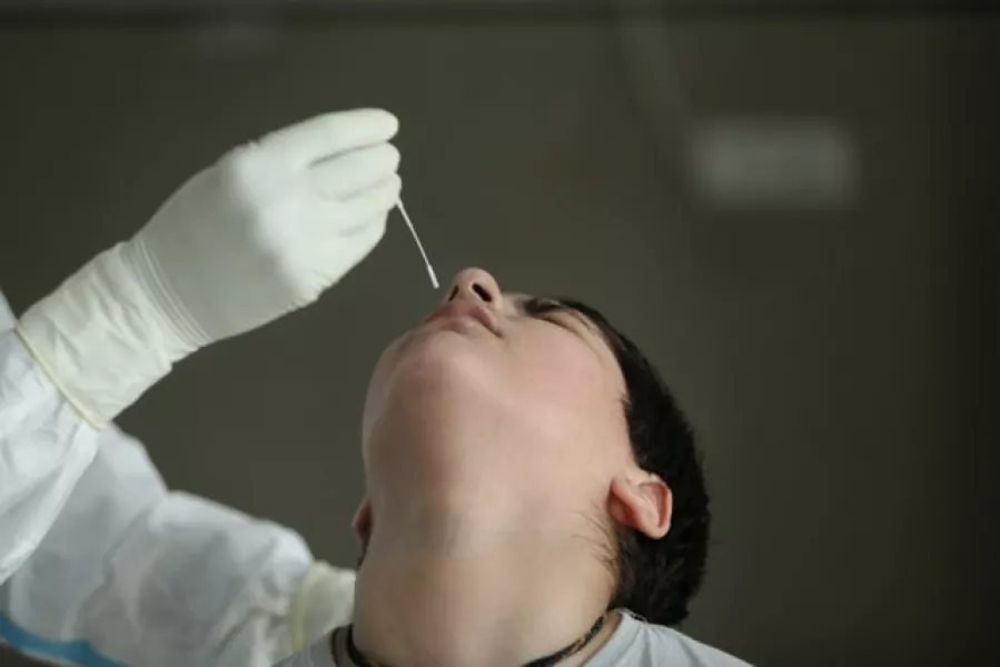 A health worker collects a swab sample at a government hospital in Jammu, India (AP/Channi Anand)