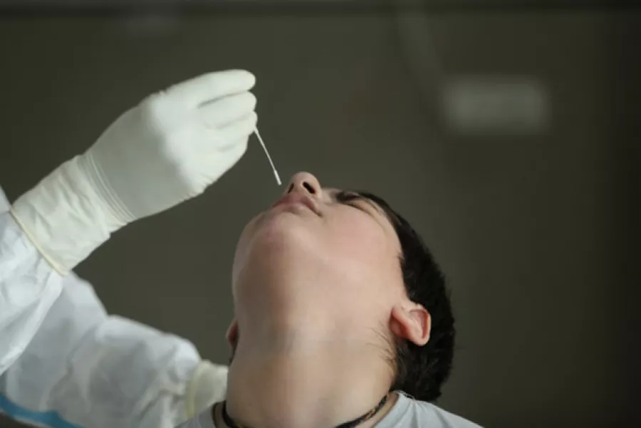 A health worker collects a swab sample to test for Covid-19 at a government hospital in Jammu, India (Channi Anand/AP)