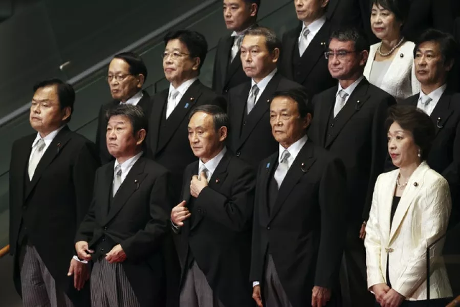 Newly elected Japanese prime minister Yoshihide Suga, centre in front row, poses with his cabinet members (Yoshikazu Tsuno/AP)