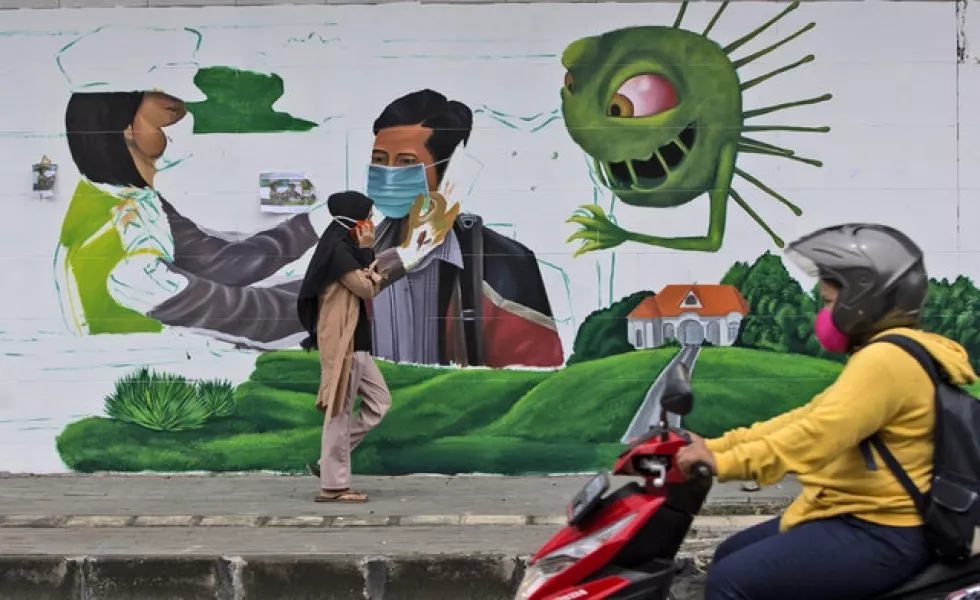 A coronavirus-themed mural intended to remind people to always wear mask in public places, in Medan, North Sumatra, Indonesia (AP)