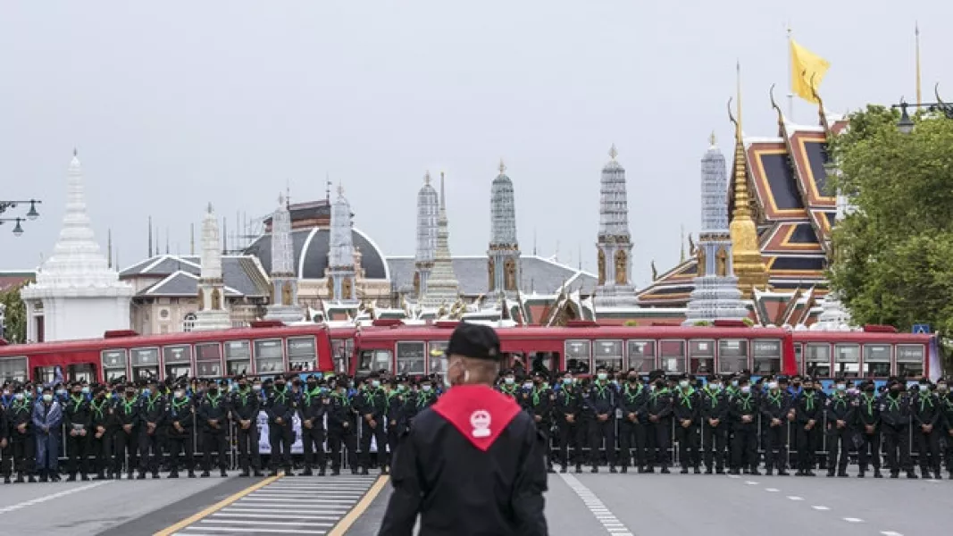 Police officers wearing face masks stand in line, protecting the area surrounding the Grand Palace during during Sunday’s protest (Wason Wanichakorn/AP)
