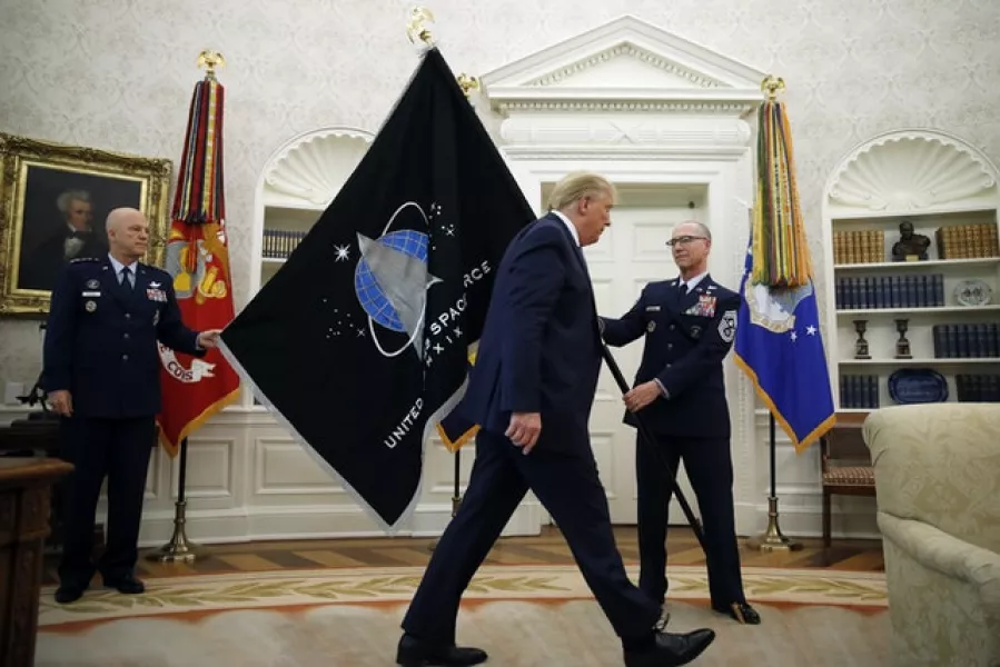 President Donald Trump walks past the US Space Force flag in the Oval Office of the White House (Alex Brandon/AP)