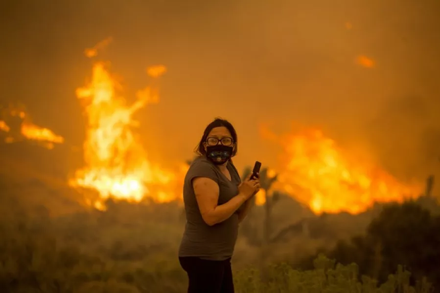 A woman watches as the Bobcat Fire burns in Juniper Hill (Ringo HW Chiu/AP)