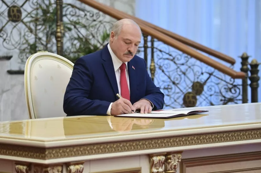 Mr Lukashenko signs the inauguration certificate (Andrei Stasevich/Pool/AP)