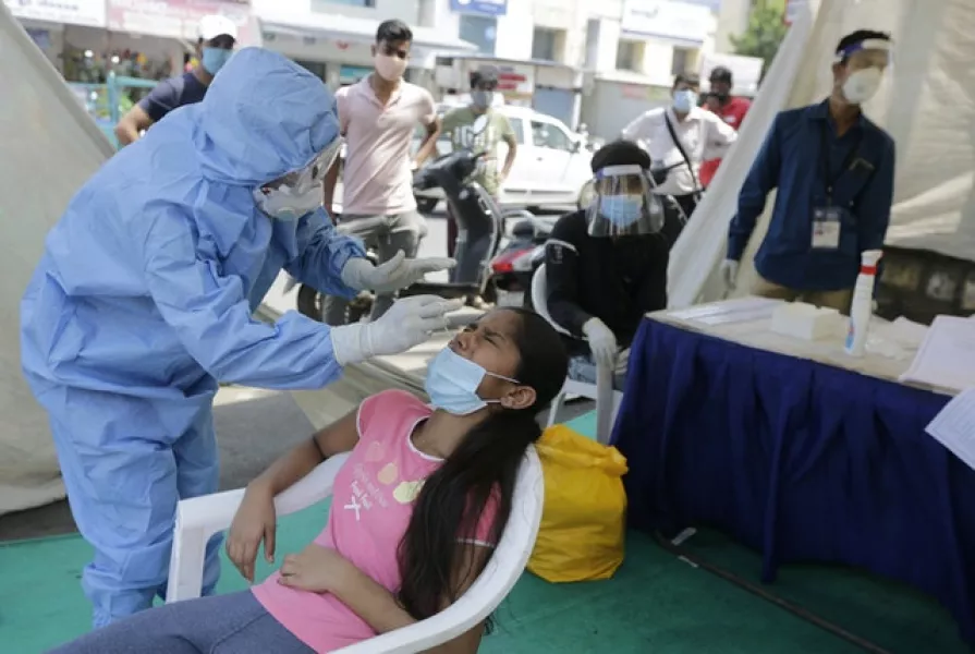 A health worker takes Covid-19 test at a facility erected to screen people in Ahmedabad, India (Ajit Solanki/AP)