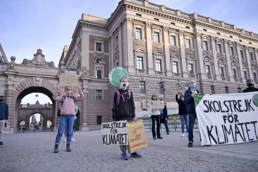 Greta Thunberg holding a sign reading ‘School strike for Climate’ in front of the Swedish Parliament (Janerik Henriksson/TT News Agency via AP)