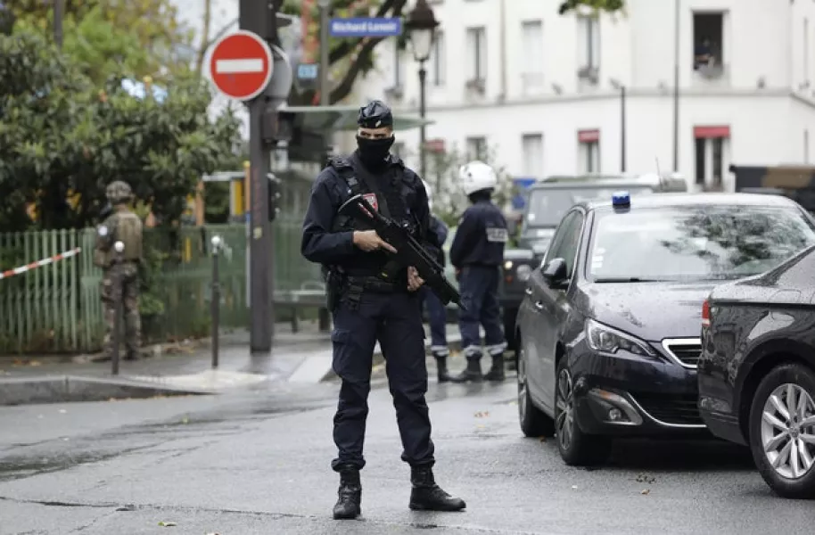 A French riot police officer stands guard after a knife attack near the former offices of satirical newspaper Charlie Hebdo (Lewis Joly/AP)