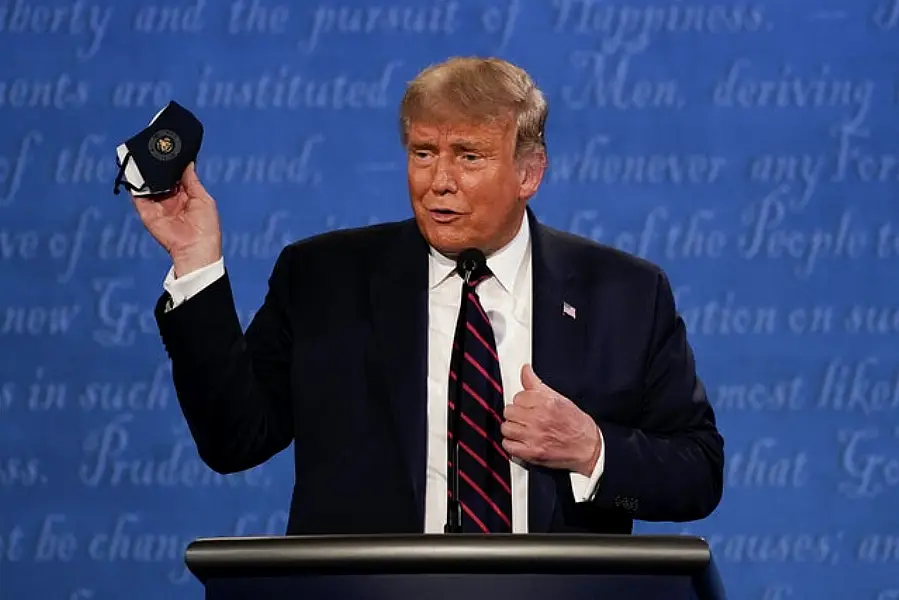 US President Donald Trump holds up his face mask (AP/Julio Cortez)