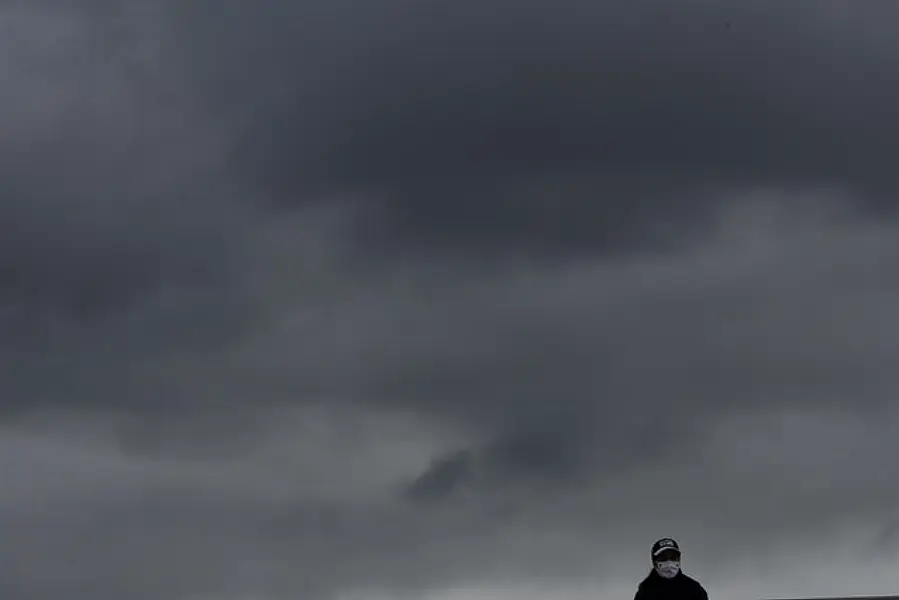 A lone spectator is silhouetted against rain clouds at the French Open tennis tournament in Paris (Alessandra Tarantino/AP)