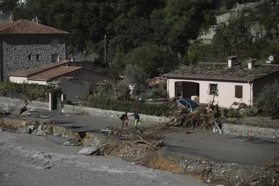 Residents try to remove a tree that fell on the road in Breil-sur-Roya, near the border with Italy (Daniel Cole/AP)