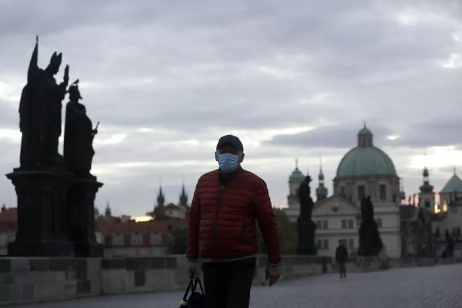 A man wearing a face mask crosses the Charles Bridge in Prague (Petr David Josek/AP)