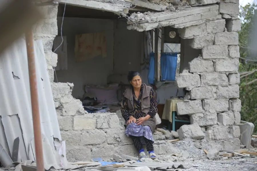 A woman sits in ruins of her house in Terter, Azerbaijan (Aziz Karimov/AP)