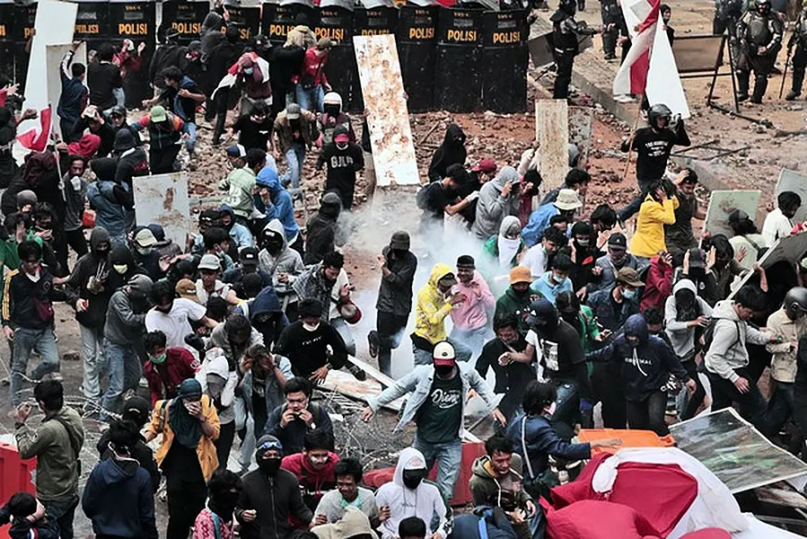 Student protesters react as police fire tear gas (AP/Dita Alangkara)