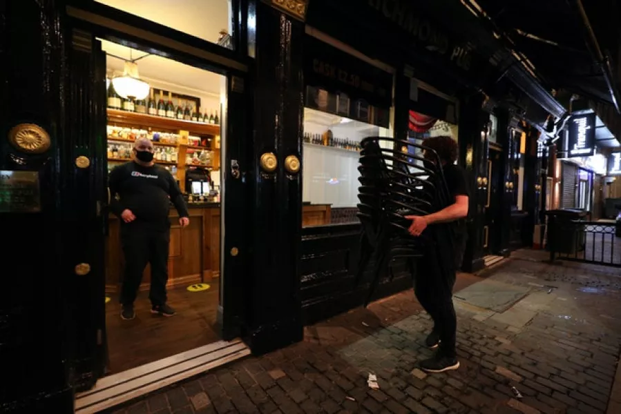 Staff at the Richmond pub in Liverpool bring in tables and chairs, as new coronavirus virus are imposed (Peter Byrne/PA)