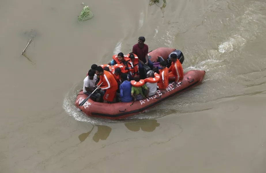 National Disaster Response Force (NDRF) personnel rescue people from floodwaters after heavy rainfall in Hyderabad, India (Mahesh Kumar A/AP)