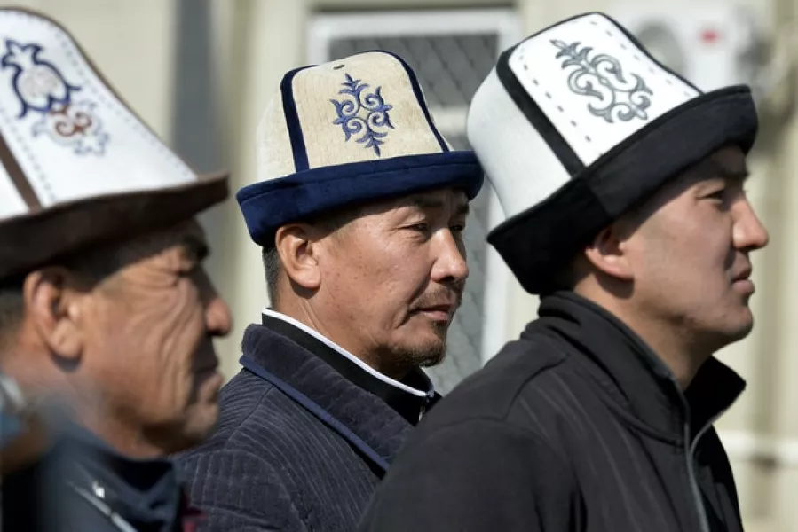 Protesters wearing Kyrgyz national hats listen to a speaker (Vladimir Voronin/AP)