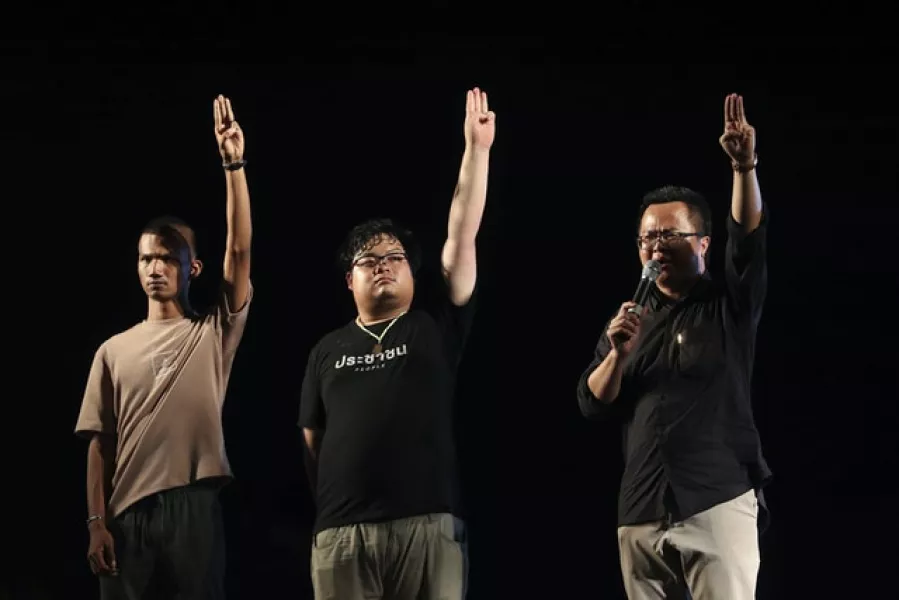 Pro-democracy activists, from left, Panupong Jadnok, Arnon Nampha, Parit Chiwarak, raise three-finger salutes, a symbol of resistance, during a protest in Bangkok (Rapeephat Sitichailapa/AP)