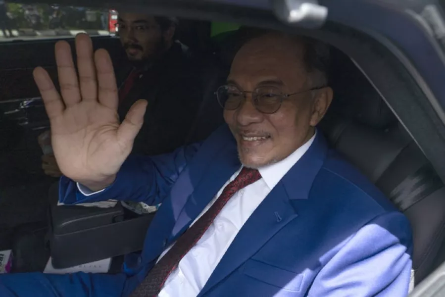 Malaysian opposition leader Anwar Ibrahim waves to media after meeting the nation’s king in Kuala Lumpur (Vincent Thian/AP)