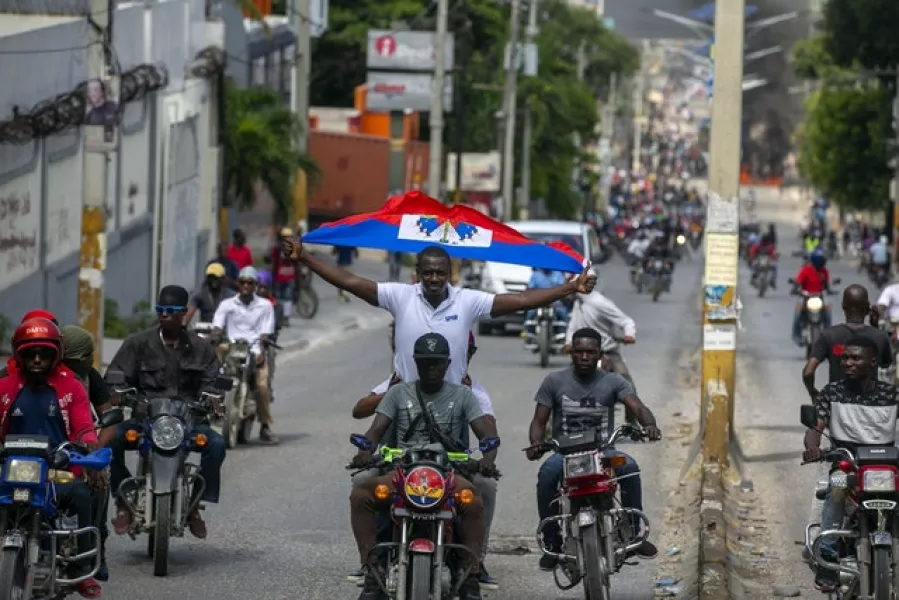 A protester holds up a Haitian national flag (Dieu Nallo Chery/AP)