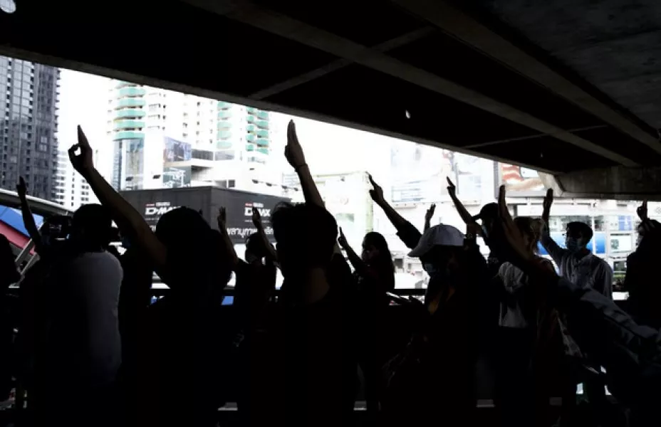 Pro-democracy protesters flash three-fingers salute against shutting down mass transport system at Ashok BTS station in Bangkok(AP)
