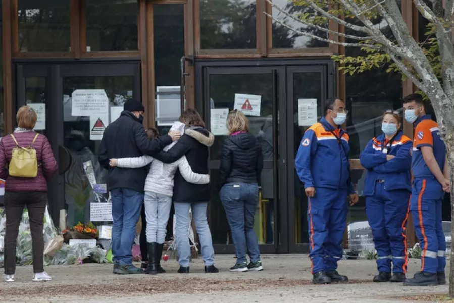 Residents pay their respects outside the entrance to the school (Michel Euler/AP)