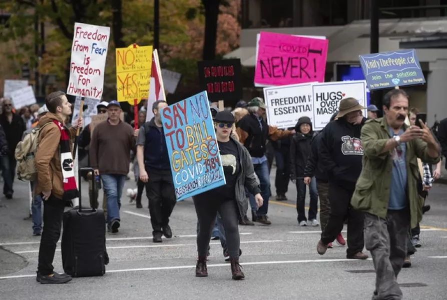 Protesters opposed to Covid-19 regulations march together after a rally in downtown Vancouver, British Columbia, Canada (AP)