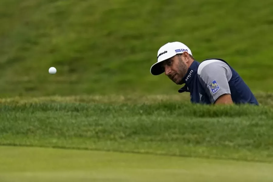 Dustin Johnson hits from the bunker on the eighth hole during the final round. Photo: AP Photo/Jeff Chiu